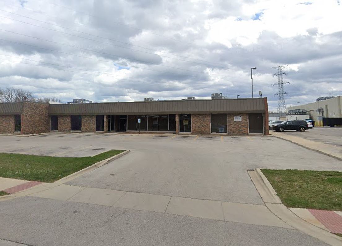 An image of the existing building at 2308 Main Street featuring a one-story brown brick shopping center built form
